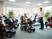 a woman sat on a mobility scooter in a showroom
