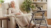 Older adult sitting comfortably in a riser recliner with a walking aid nearby, showing winter home safety and independence.