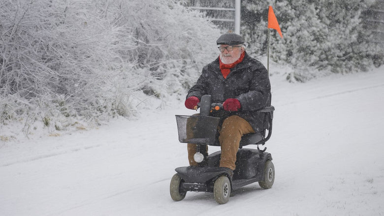 a gentleman riding a mobility scooter in wintery conditions