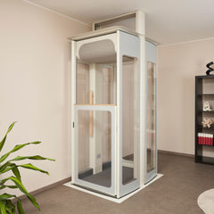 Stannah S3 home lift in a room with a plant and bookshelf.